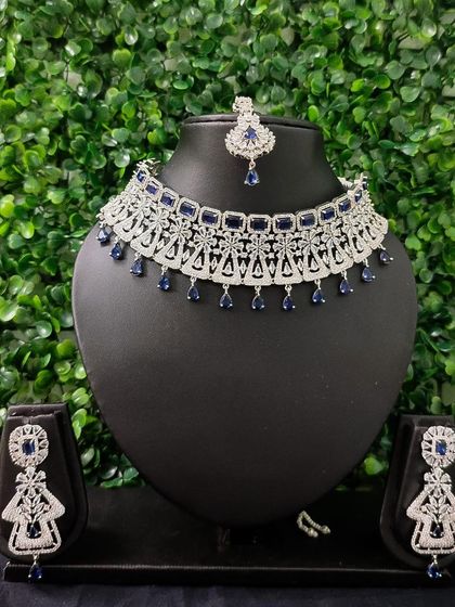 The full view of the sapphire-blue AD set, including the necklace, earrings, and matching maang tikka.