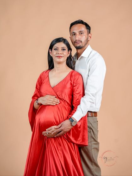 A classic and loving pose for an expecting couple. The partner's hands gently placed on the baby bump symbolize their shared journey into parenthood.