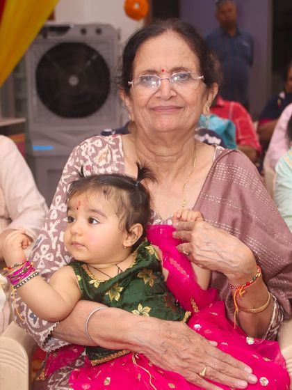 A grandmother holds her infant grandchild, a precious multi-generational moment.