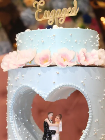 A detailed view of the top of the blue engagement cake, showing the intricate pearl work and the dancing couple figurine. It’s these small touches that create a truly memorable centerpiece.