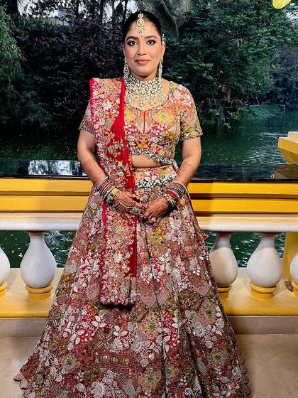 The full bridal look, showcasing the intricate floral lehenga and the makeup that complements its vibrant colors.