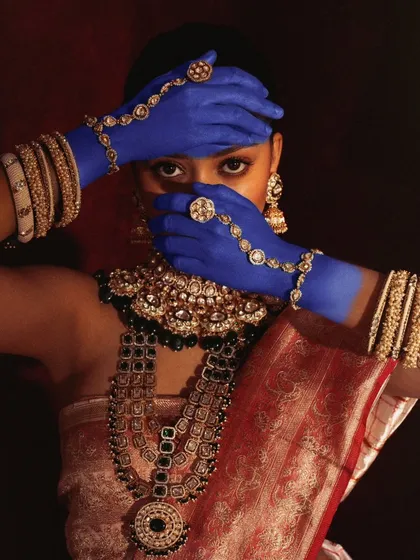 A striking image from a conceptual beauty shoot, where we used bold blue paint to contrast with the traditional saree and heavy Polki jewelry. The hands covering the face create a sense of mystery and draw attention to the adornments.