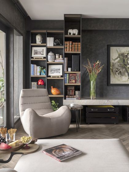 A cozy reading nook in the Caitriona apartment, featuring the comfortable 'Botero Chair' and a well-stocked bookshelf. It's a perfect example of how we create small moments of comfort and personality within a larger space.