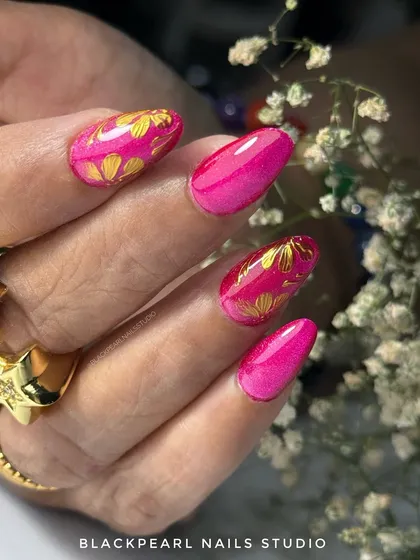 Another angle of the hot pink cat eye nails with golden chrome flowers, showing off the intricate details and vibrant color. This set is designed to turn heads and elevate any look.
