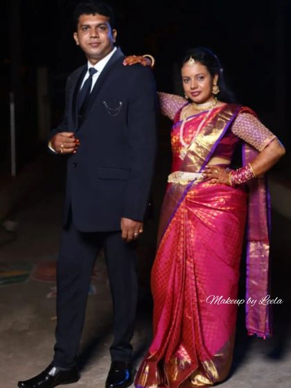A full-length photo of the couple, showcasing the bride's complete reception look. Her saree is draped perfectly, and her makeup is designed to look great from every angle.