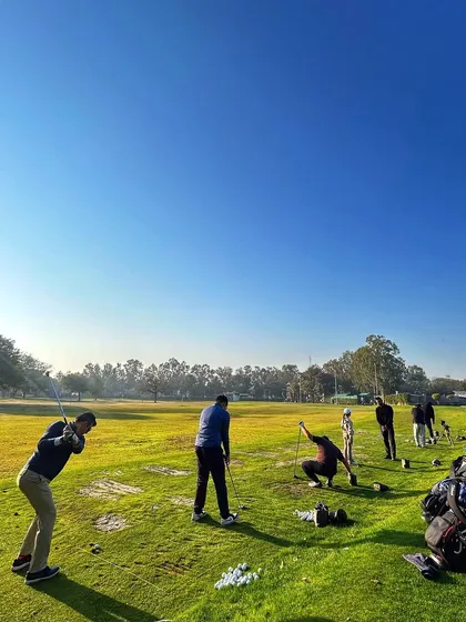 A group of friends enjoys a sunny day on the range, with clear blue skies above.