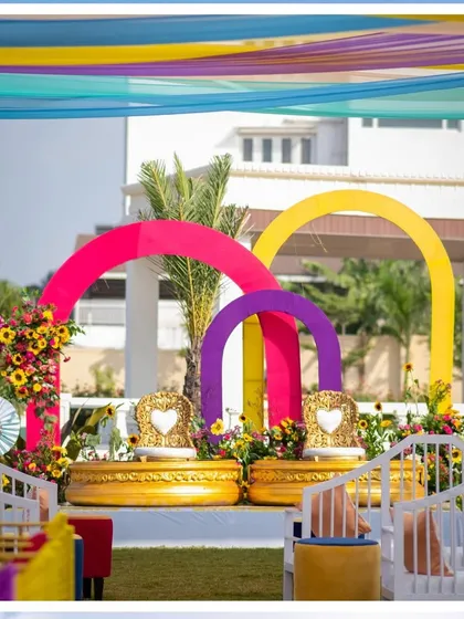 A closer look at the Haldi stage with its bright pink, purple, and yellow arches, designed for a fun, Holi-themed event.
