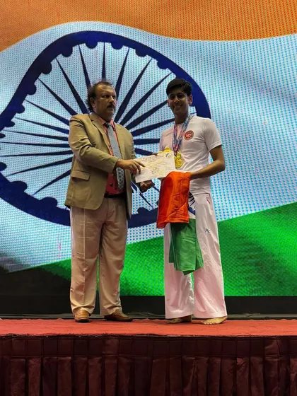 Holding the certificate and medal with pride. Shandai Tanishq Jain is officially recognized for his silver medal win, a result of his dedication and the rigorous training at our academy.