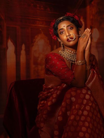 A prayer-like pose, capturing a moment of quiet contemplation amidst the grandeur of the festive styling.