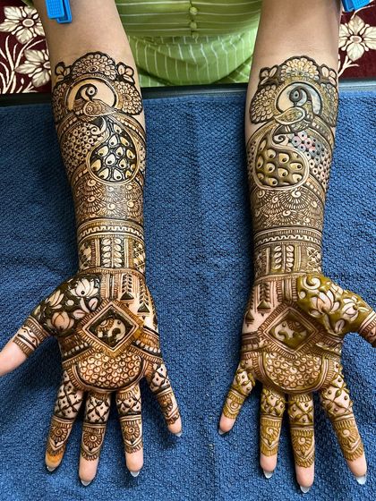 A gorgeous engagement design featuring peacocks on the forearms and intricate patterns on the palms.