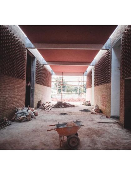 A construction view of the memorial hall, with rubble and a wheelbarrow showing the reality of the building process.