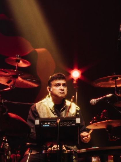 A duplicate of image 23, our drummer, Tarun Bangalore, holding down the groove with intense focus. His powerful drumming drives the energy of our large-scale fusion performances.