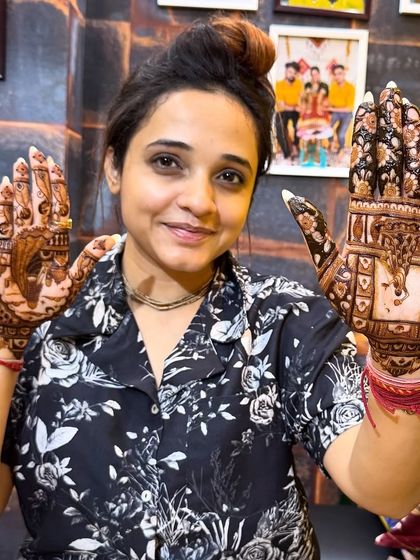 Another pose from our happy client, showcasing both hands with different but complementary Karwa Chauth themed designs.