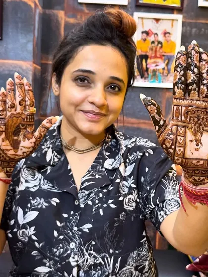 Another pose from our happy client, showcasing both hands with different but complementary Karwa Chauth themed designs.