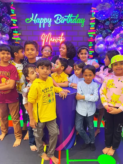 The birthday crew glowing with happiness! A group of kids posing in the custom neon-lit party space, showing how the theme brings everyone together for a memorable photo.
