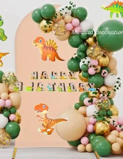 Here is another take on a dinosaur theme, using a softer color palette. The organic balloon arch in green, beige, and gold is decorated with various dinosaur cutouts and a matching 'Happy Birthday' banner.