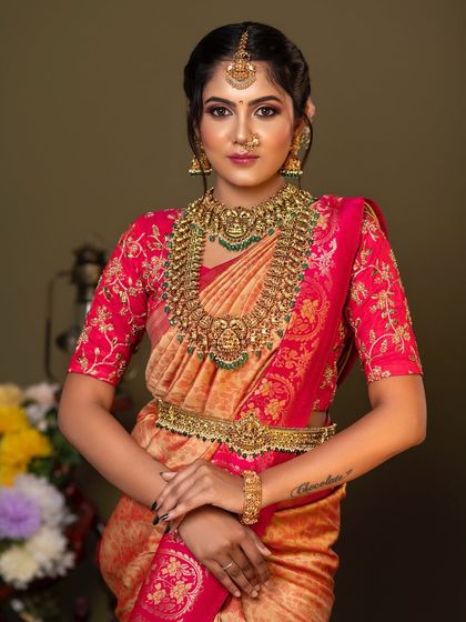 A confident and beautiful pose. The intricate details of the temple jewellery, from the choker to the haram, are clearly visible, showcasing the quality of our rental collection.