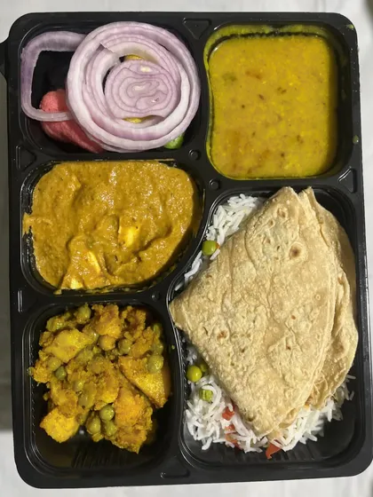 This is my standard daily vegetarian thali, perfect for your office lunch or a simple dinner. It includes soft chapatis, vegetable rice, dal, a paneer curry, a dry vegetable sabzi, and a fresh salad.