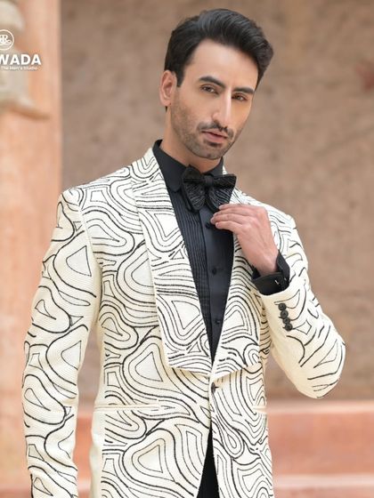 This white tuxedo jacket with black abstract sequin embroidery is a modern masterpiece. It's a perfect choice for a glamorous reception or cocktail event.