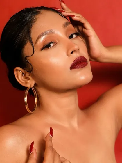 A confident and powerful pose that channels old Hollywood elegance. The red lip and nails create a cohesive and striking statement.