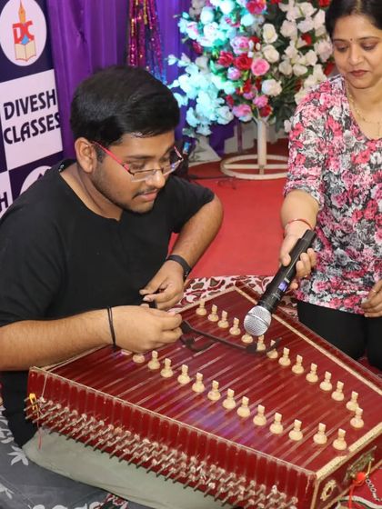 A talented student showcasing his skills on the santoor, a classical instrument, during the farewell ceremony's talent segment.