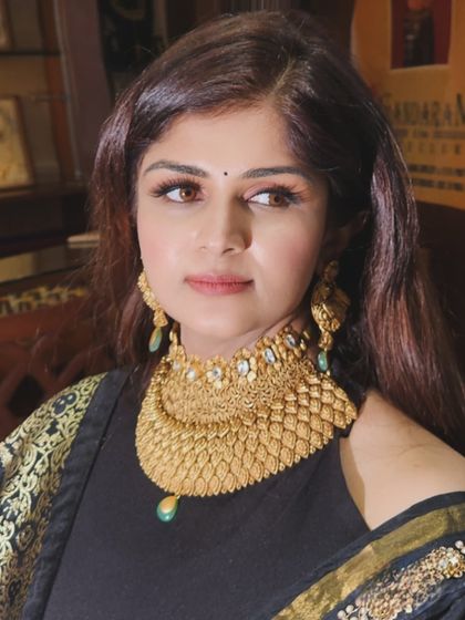 A close-up of a magnificent gold temple jewelry necklace, a symbol of tradition and prosperity.