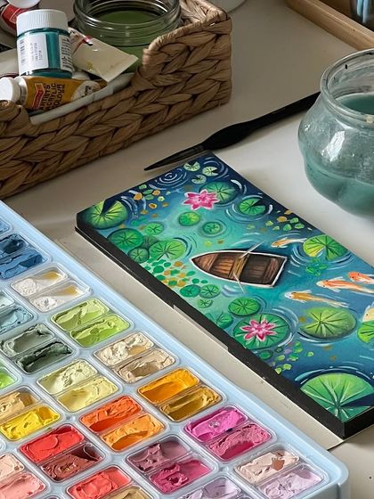 The finished koi pond painting, with its vibrant colors and intricate details, resting on my desk.