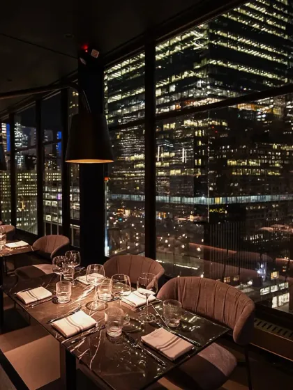 The magic of a New York City evening from our One40 Rooftop restaurant project. We designed this space to capture the city's energy, with floor-to-ceiling windows that frame the glittering skyline, creating an unforgettable dining atmosphere.