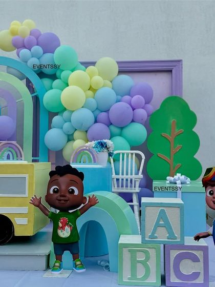 JJ and his friend are ready to party in this setup, which includes pastel ABC blocks and a rainbow backdrop.