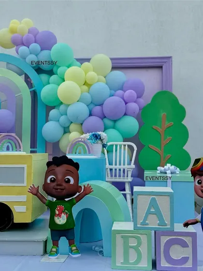 JJ and his friend are ready to party in this setup, which includes pastel ABC blocks and a rainbow backdrop.