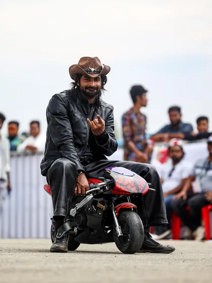 Even the racers have fun. A participant poses on a tiny pocket bike, showcasing the lighthearted and community-focused spirit that exists alongside the fierce competition.