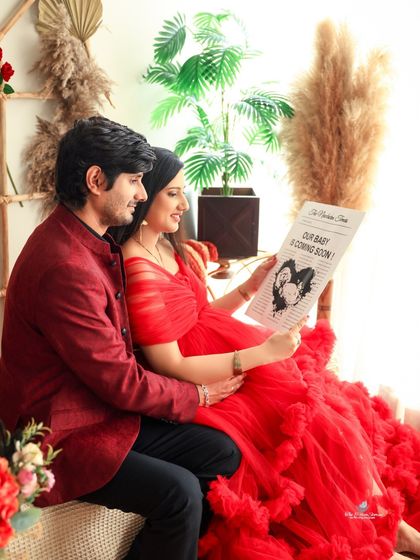 The couple reads the "Our Baby is Coming Soon" news together, sharing a happy and candid moment. This prop adds a wonderful storytelling element to the shoot.
