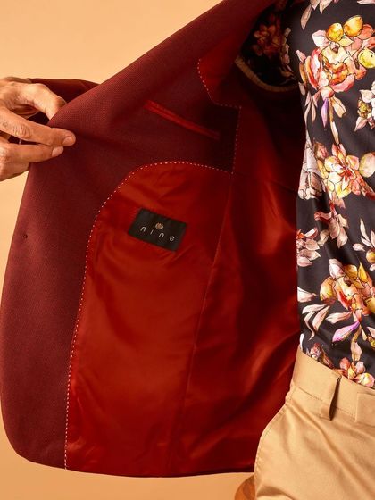 A look inside the maroon blazer, revealing the smooth satin lining and clean interior stitching. Craftsmanship is key, inside and out.