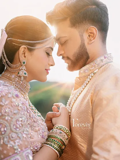 Capturing the romance of the moment. This couple's coordinated outfits feature a stunning 3D floral embroidered saree and blouse for her, paired with a custom sherwani for him, creating a picture-perfect memory.