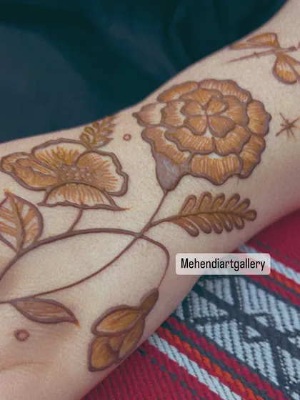 A close-up of a modern floral design with a dragonfly accent. This whimsical and nature-inspired piece is perfect for someone looking for a unique henna tattoo.