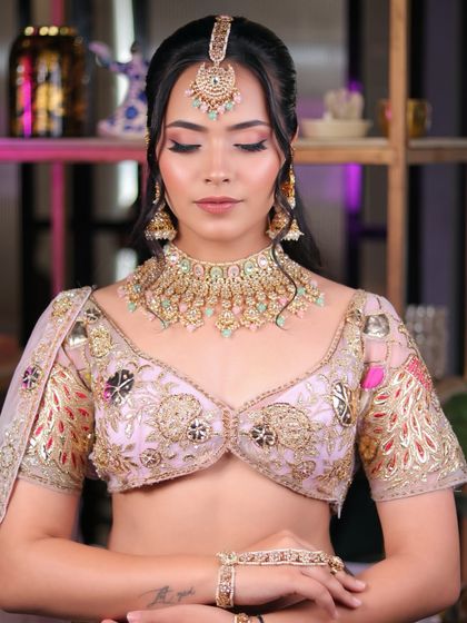 This graceful and traditional look features soft pink eyeshadow and a flawless base, paired with a beautiful pastel lehenga and kundan jewelry.
