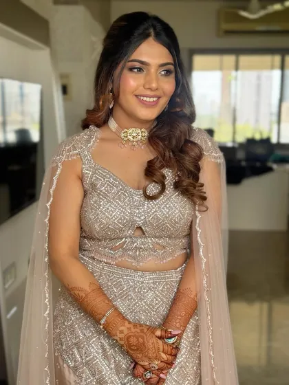 A smiling portrait of the client. The half-up style is a great way to show off statement earrings and a necklace.