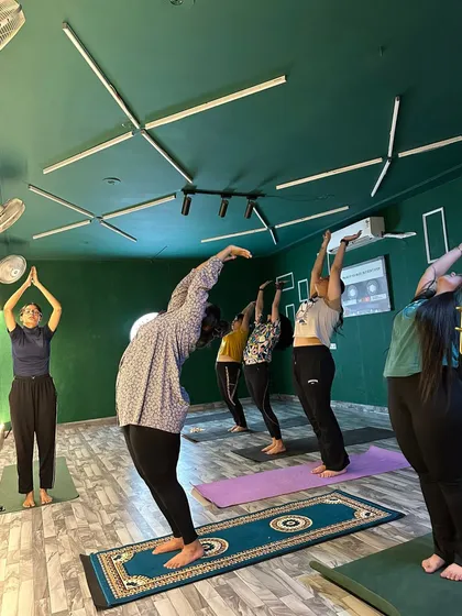 Finding balance and strength in our group yoga class. Here, our members are practicing a standing backbend, or Anuvittasana, to improve posture and flexibility. Our certified instructor ensures everyone maintains proper form for a safe and effective stretch.
