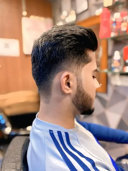 A clean and sharp look for men. This haircut features a precise skin fade on the sides that blends perfectly into the styled hair on top, creating a modern and stylish profile.