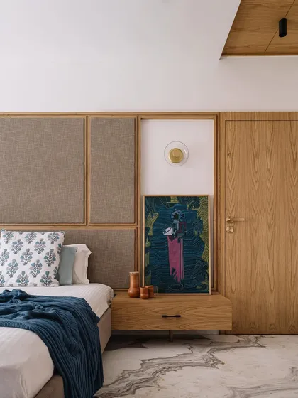 This bedroom corner in the Cocoon House showcases our focus on creating serene, personal sanctuaries. We combined a fabric-panelled headboard with a natural wood frame, setting it against a backdrop of carefully chosen art and soft textiles to create a space that feels both minimalist and lived-in.