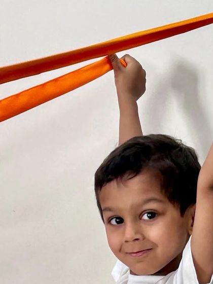 A close-up of a happy student participating in the ribbon activity. Our goal is to create positive and joyful musical experiences, and our training focuses on the techniques that bring out this natural enthusiasm in children.