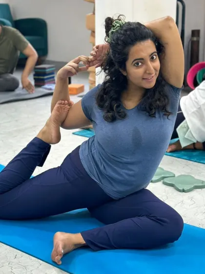 The joy of the practice shines through as this student smiles in her Eka Pada Rajakapotasana, a testament to finding comfort in challenging poses.