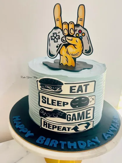 Eat, Sleep, Game, Repeat. This cake is for the ultimate gamer, featuring a controller and the gamer's life motto.