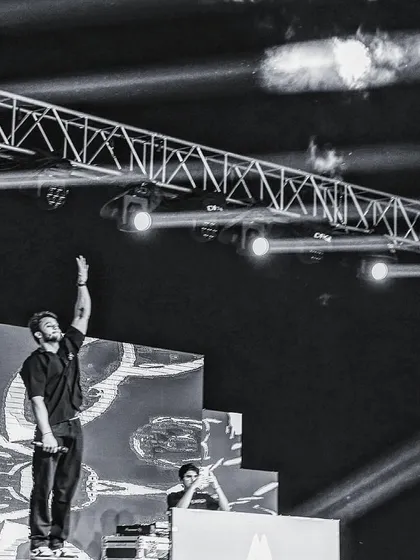 A black and white shot from the stage, standing on the console to hype up the crowd. I'm an entertainer first, and I'll do whatever it takes to elevate the energy of the show.