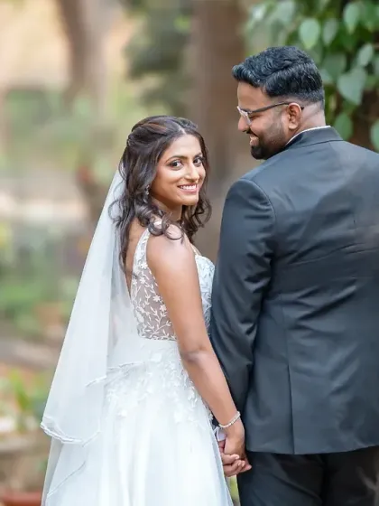 That "look back at it" shot. A fun and sweet portrait of the bride looking back with a smile as she leads her groom.