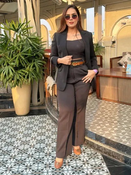 A full-length view of a powerful and polished corporate look. The combination of a fitted top, high-waisted trousers, and a sharp blazer creates a balanced and authoritative style statement.