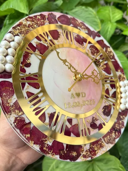 An angled shot that highlights the glossy, smooth surface of the resin and the elegant golden clock dial.