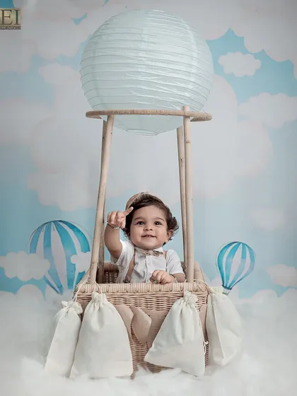 Waving from his hot air balloon, this baby is ready for a sky-high journey. These whimsical shots are perfect for capturing a sense of wonder and imagination.
