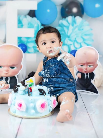 This little "Boss Baby" is covered in cake and loving it! A classic messy cake smash moment that families will laugh about for years.