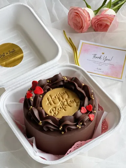 For the ultimate chocolate lover, my rich chocolate truffle bento cake is a dream. It features a deep chocolate buttercream, elegant piping, and a custom "Happy Birthday" gold stamp for a touch of luxury.